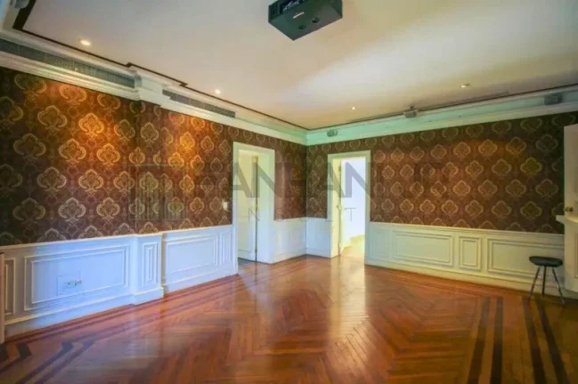 Imagem Luxuosa casa de alto padrão de 4 suítes no Jardim América: 6 salas, 8 banheiros, 12 vagas de garagem e 1.029m² de área em SP.