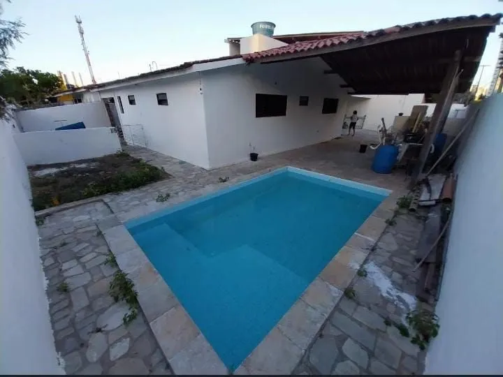 Foto do imóvel Casa Duplex em Brisamar com 3 suítes, piscina, varanda, cozinha americana e localização privilegiada próxima às praias.