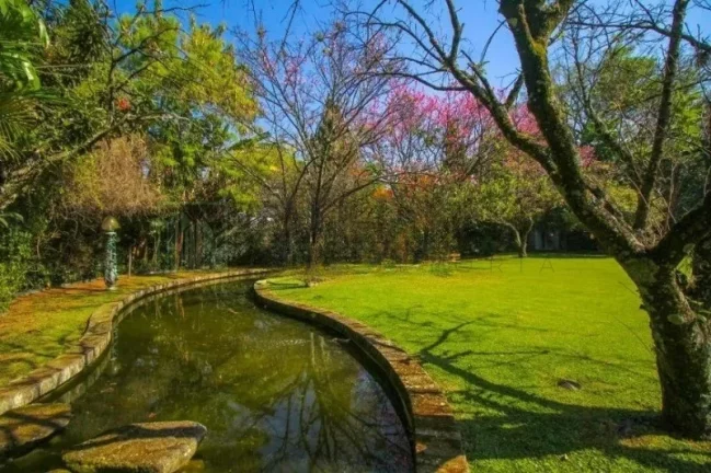 Imagem Luxuosa casa de alto padrão de 4 suítes no Jardim América: 6 salas, 8 banheiros, 12 vagas de garagem e 1.029m² de área em SP.