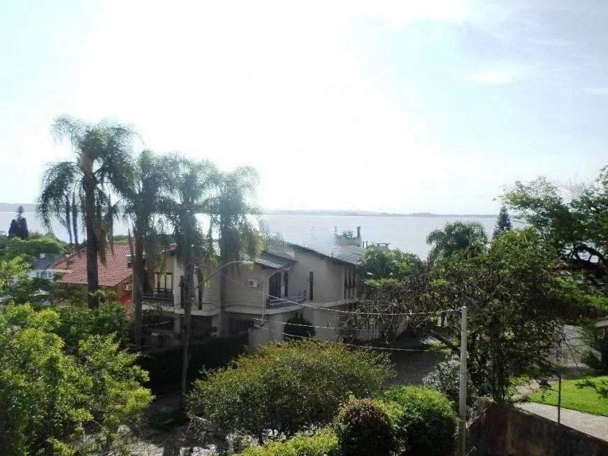 Imagem residência com vista panorâmica espetacular para o Guaíba em todos os cômodos da casa, hall de entrada, gabinete, lavabo, living para três ambientes com sacada e vista