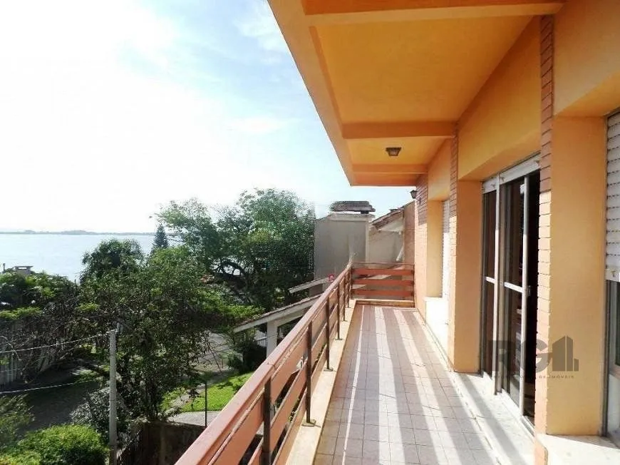 Imagem residência com vista panorâmica espetacular para o Guaíba em todos os cômodos da casa, hall de entrada, gabinete, lavabo, living para três ambientes com sacada e vista