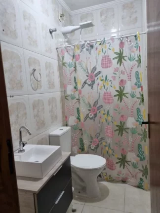 Imagem Sobrado individual à venda no Maracanã em Praia Grande-SP, com 2 dormitórios sendo suítes, sala ampla, cozinha com armários planejados, 1 lavabo, banheiro com box e gabinete, lavanderia, churrasqueira, vaga de garagem, portão em alumínio, a 150 metros da 