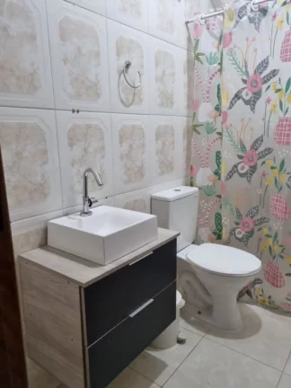 Imagem Sobrado individual à venda no Maracanã em Praia Grande-SP, com 2 dormitórios sendo suítes, sala ampla, cozinha com armários planejados, 1 lavabo, banheiro com box e gabinete, lavanderia, churrasqueira, vaga de garagem, portão em alumínio, a 150 metros da 