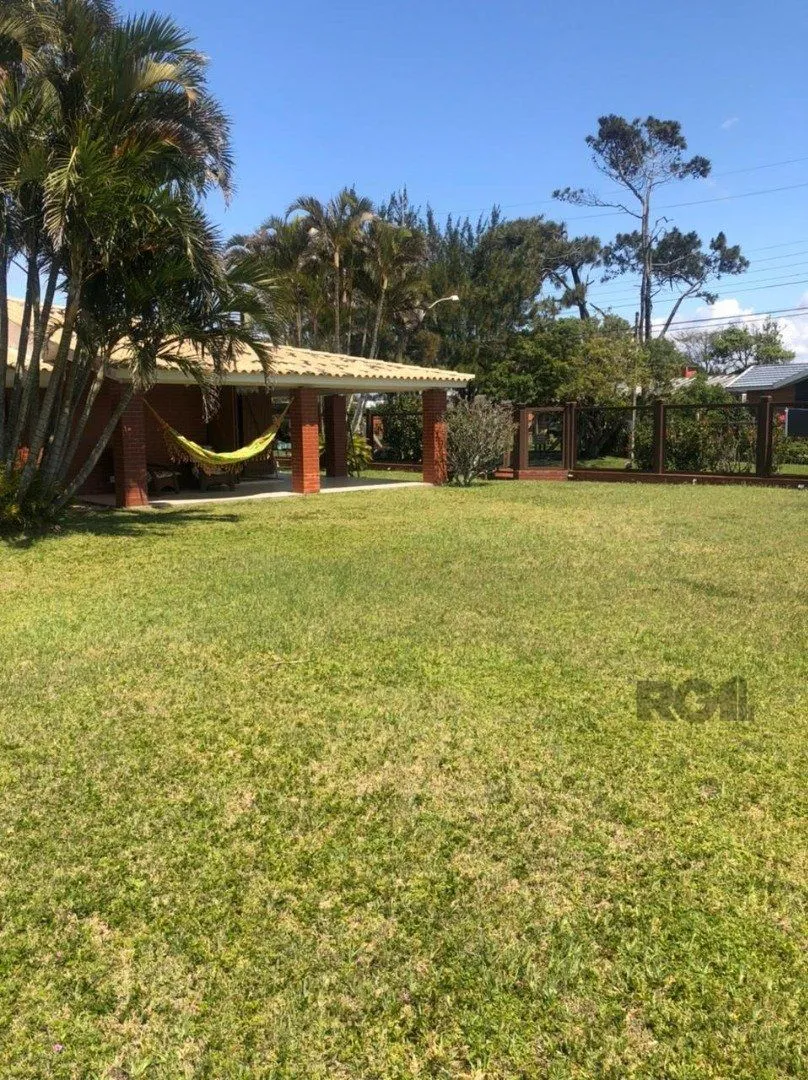 Imagem Espaçosa e acolhedora residência numas das esquinas em charmosa rua de Atlântida, com imenso jardim, paisagismo, lareira,4 dormitórios, sendo duas suítes.