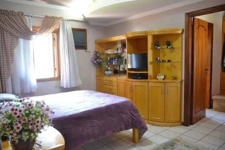 Imagem Casa Comercial e Residencial com 518m² (4 quartos / 5 banheiros / 3 vagas garagem) no Bairro Partenon localizada à meia quadra da Av. Bento Gonçalves.