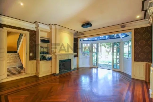 Imagem Luxuosa casa de alto padrão de 4 suítes no Jardim América: 6 salas, 8 banheiros, 12 vagas de garagem e 1.029m² de área em SP.