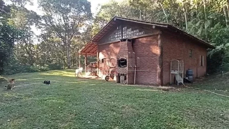 Imagem Sitio com duas casas, a primeira casa de tijolinho tem janelas de alumínio, churrasqueira, varanda ...