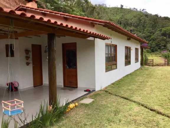 Sitio com ampla casa térrea com varanda ampla lateral.