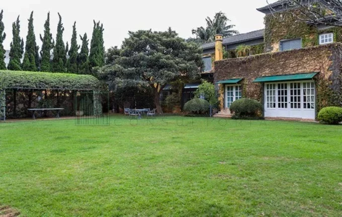 Imagem Luxuosa casa de alto padrão de 4 suítes no Jardim América: 6 salas, 8 banheiros, 12 vagas de garagem e 1.029m² de área em SP.
