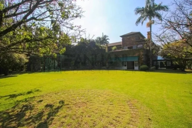 Imagem Luxuosa casa de alto padrão de 4 suítes no Jardim América: 6 salas, 8 banheiros, 12 vagas de garagem e 1.029m² de área em SP.