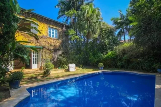 Imagem Luxuosa casa de alto padrão de 4 suítes no Jardim América: 6 salas, 8 banheiros, 12 vagas de garagem e 1.029m² de área em SP.