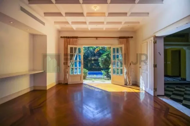 Imagem Luxuosa casa de alto padrão de 4 suítes no Jardim América: 6 salas, 8 banheiros, 12 vagas de garagem e 1.029m² de área em SP.