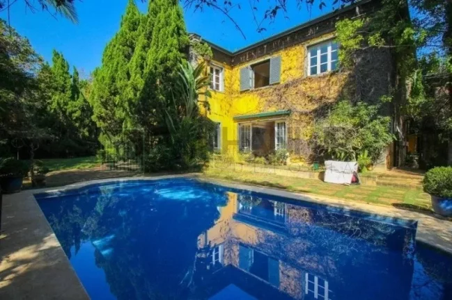 Imagem Luxuosa casa de alto padrão de 4 suítes no Jardim América: 6 salas, 8 banheiros, 12 vagas de garagem e 1.029m² de área em SP.