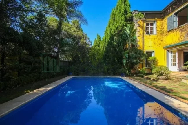 Imagem Luxuosa casa de alto padrão de 4 suítes no Jardim América: 6 salas, 8 banheiros, 12 vagas de garagem e 1.029m² de área em SP.